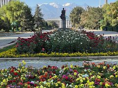 05A Flowers frame the view down Kyrgyz National State University to a statue of Shabdan Baatyr, Bishkek City Hall, and mountains beyond Bishkek Kyrgyzstan